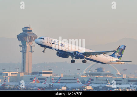 JetBlue Airways Airbus A321 Avion de ligne à décoller de la piste 25 gauche à l'Aéroport International de Los Angeles. La nouvelle tour de contrôle en arrière-plan. Banque D'Images