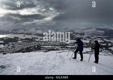 Les randonneurs suivent le Latrigg marche pour apprécier la vue du lac Derwentwater, près de la ville de Keswick, qui est recouverte de neige, comme temps de gel grips au Royaume-Uni et les fortes chutes de neige a conduit à l'interruption de voyage. Banque D'Images