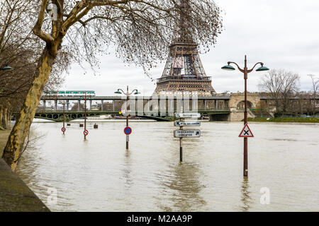 La Seine gonflé pendant l'hiver les inondations épisode de janvier 2018, avec la moitié immergé de signalisation et éclairage de rue dans le premier plan et la Tour Eiffel Banque D'Images