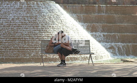 San Antonio, Texas - 20 Février 2011 : Romantic couple assis sur le banc près de la fontaine sur Riverwalk de San Antonio, Texas. Banque D'Images