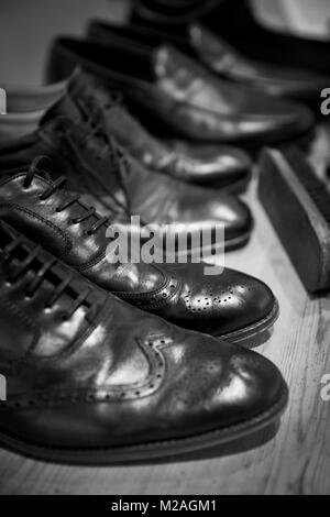 Ligne de chaussures d'hommes avec brosse à chaussure, close-up, noir et blanc Banque D'Images