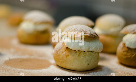 Les jours gras traditionnel bun - semla sur une planche à découper, saupoudrés de sucre. Banque D'Images