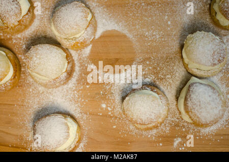 Les jours gras traditionnel bun - semla sur une planche à découper, saupoudrés de sucre. Banque D'Images