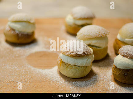 Les jours gras traditionnel bun - semla sur une planche à découper, saupoudrés de sucre. Banque D'Images