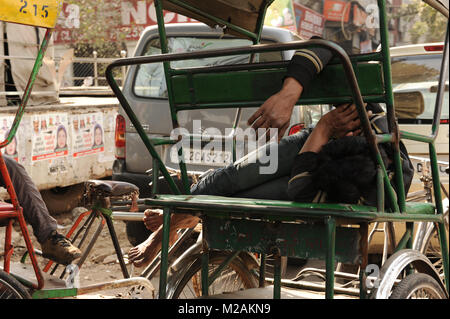 Un homme dort sur son rickshaw Banque D'Images