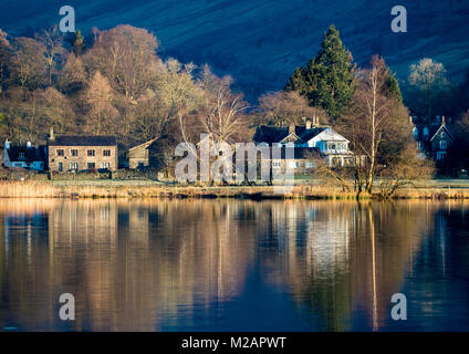 Maisons qui se reflètent dans les eaux calmes de Grasmere dans le Lake District, Cumbria, Royaume-Uni Banque D'Images