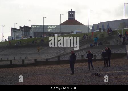 Famille dimanche promenade le long de la plage d''Aberdeen avec la promenade et de la plage de bal en arrière-plan. Nord-est de l'Écosse, au Royaume-Uni. Février, 2018. Banque D'Images