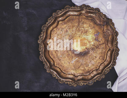 Plaque de cuivre rond vide avec monogrammes sur un fond en bois noir, vue de dessus, l'espace vide Banque D'Images