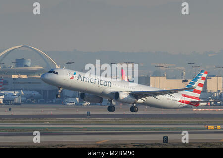 American Airlines Airbus A321 décollant de la piste 25 gauche à l'Aéroport International de Los Angeles tôt le matin. Le thème bâtiment derrière. Banque D'Images