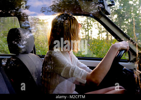 Femme au volant voiture près de Forest Banque D'Images