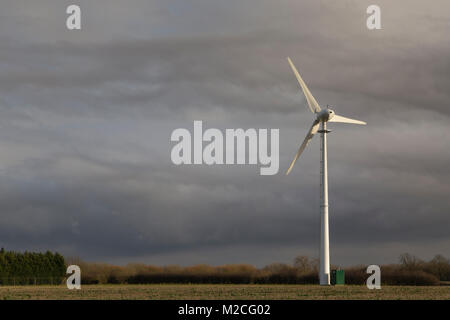 Image d'une éolienne contre un ciel d'orage en fin de soirée,soleil. Banque D'Images