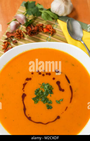 Soupe de potiron dans un bol blanc épicé avec du persil et de l'huile de citrouille. Banque D'Images