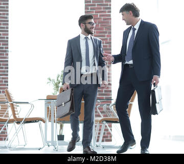 Deux hommes d'en marchant le long d'un immeuble de bureaux moderne Banque D'Images
