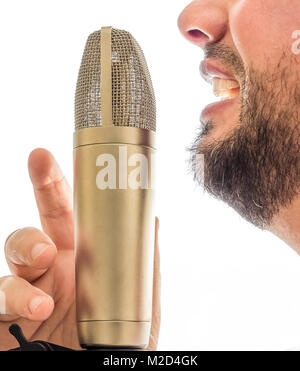 Un microphone d'or est situé en face d'un visage des hommes. Le mâle est de chanter dans le micro. L'arrière-plan est tout blanc. Banque D'Images