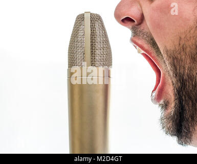 Un microphone d'or est situé en face d'un visage des hommes. Le mâle est de crier dans le micro. L'arrière-plan est tout blanc. Banque D'Images