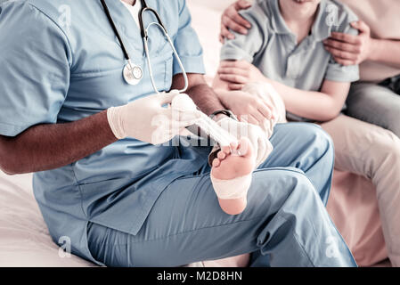 Close up of medical worker putting bandage sur pied Banque D'Images