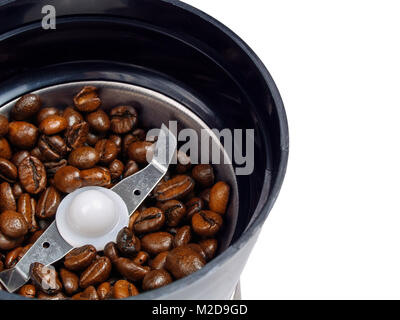 Broyeur à café électrique close-up vue du dessus avec rôti entier grains de café versé dans c Banque D'Images