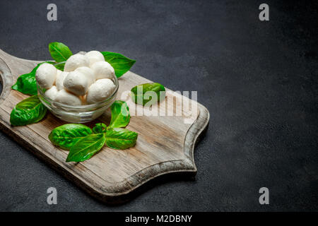 La cuisine italienne traditionnelle de fromage mozzarella et basilic sur béton foncé Banque D'Images