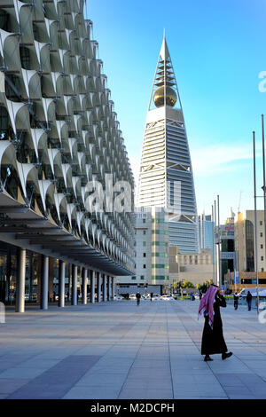 25 janvier 2017 - Riyadh, Arabie Saoudite : un homme marche à proximité du parc du Musée national de l'Arabie et Al Faisaliyah Center Tower en arrière-plan le long d'Olaya Banque D'Images