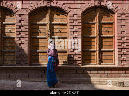 Femme marche en face de vieille maisons haveli, Bikaner, Rajasthan, India Banque D'Images