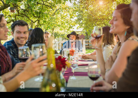 Les amis de boire du vin au party outdoors Banque D'Images