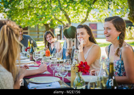 Les femmes de race blanche de parler à table au party outdoors Banque D'Images