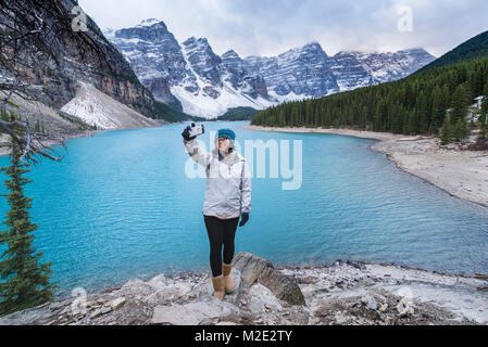 Asian woman posing for cell phone à selfies mountain lake Banque D'Images