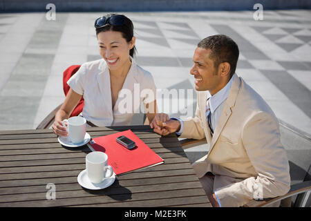Couple holding hands et boire du café en plein air Banque D'Images