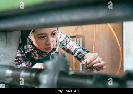 De beaux gros plan jolie femme le personnel travaillant sur machine de tour company et dispositif de commande pour pièces de process en cours de concentration sélective. ministère foc Banque D'Images