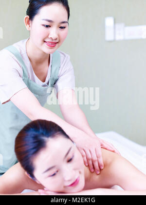 Jeune masseuse asiatique offrant un service de massage pour female customer in Beauty Spa, se concentrer sur la masseuse. Banque D'Images