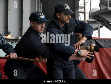 BREMERTON, dans l'(fév. 1, 2018) l'Aviation-électricien 2e classe Michael Diaz, de Eatontown, New Jersey, à gauche, et l'électronique d'aviation aviateur Technicien Jalyn Robertson, de Pomona, en Californie, la pratique des techniques de manipulation d'incendie sur la plage arrière à bord du USS JOHN C. STENNIS (CVN 74) lors d'un rodéo de contrôle des dommages. John C. Stennis est à port effectuant un exercice de routine en tant qu'il continue la préparation de son prochain déploiement. (U.S. Navy Banque D'Images