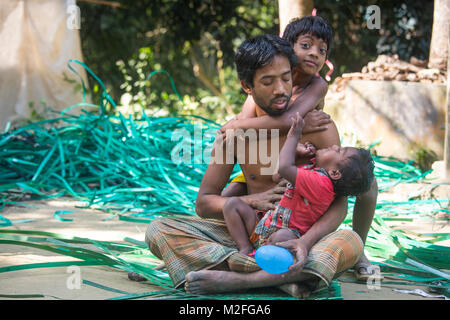 Le Bangladesh, Manikgonj. 7 Février, 2018. L'homme est un village dans la ville de weave. La profession de l'homme était en bambou ou le tissage du tissu, mais dans la ville il n'a pas obtenu tout le bambou ou en tissu de fils, il a choisi de faire du tricotage le gaspillage de plastique. Aujourd'hui, lui et ses enfants, tous ensemble, avec les matières plastiques. Il y a tant de familles de la région qui vivent leur vie de cette façon. Credit : Jahangir Alam Onuchcha/Alamy Live News Banque D'Images