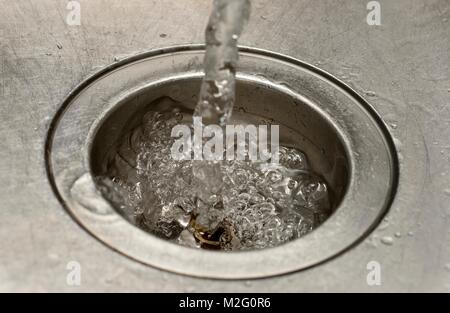 Verser de l'eau dans une macro close up plughole Banque D'Images