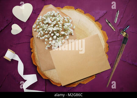 Plume calligraphique, se trouve à proximité d'un cercle en bois avec un papier blanc coeur. carte de souhaits pour la Saint-Valentin avec place pour votre texte. Mise à plat, haut voir photo maquette Banque D'Images