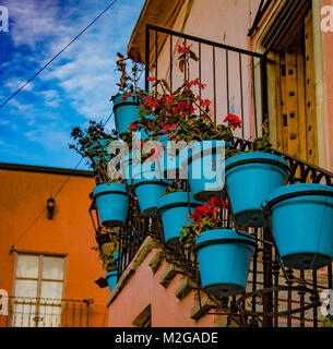 Bleu coloré avec des pots de plantes rouges sur metal escalier rustique dans la rue Banque D'Images