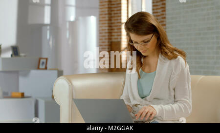 Jeune femme occupée à travailler sur un ordinateur portable à la maison, jeune entreprise, freelance HD Banque D'Images