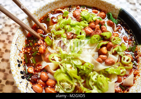 Soupe de nouilles épicées avec des légumes, des herbes, de cacahuètes et de coriandre, populaire dans la province de Yunnan, profondeur de champ, la Chine. Banque D'Images