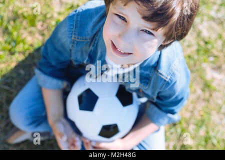 Cute boy with ball smiling après playing soccer Banque D'Images