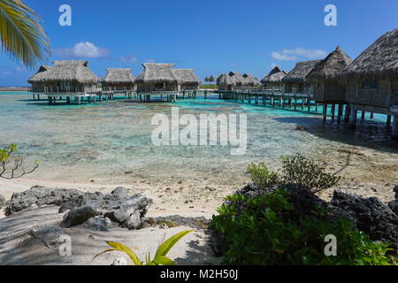 Tropical Island resort avec des bungalows sur pilotis dans le lagon, l'atoll de Tikehau, Tuamotu, Polynésie Française, océan Pacifique, Océanie Banque D'Images