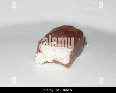 Chocolat bounty bar sur la surface blanche des bonbons à moitié mangé des aliments ; l'essex ; Angleterre ; uk Banque D'Images