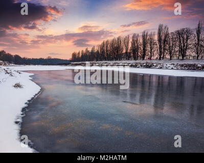 Magnifique coucher de soleil sur la rivière gelée. Nealezhnosti Uzhogorod en remblai emplacement. début de la plus longue allée de tilleul en hiver Banque D'Images