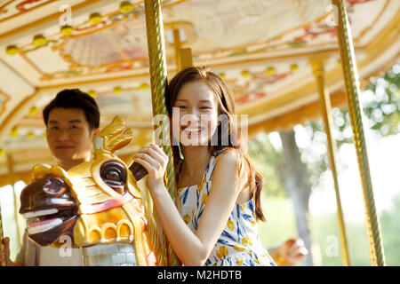 Les jeunes amoureux équitation joyeux se déplace sur le terrain de jeux Banque D'Images