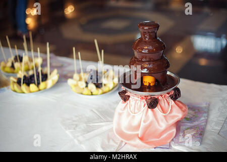 Fontaine au chocolat avec des fruits préparés sur la table Banque D'Images