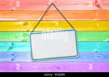 Plaque Metal sign sur un arc-en-ciel de couleurs pastel planches en bois peint contexte Banque D'Images