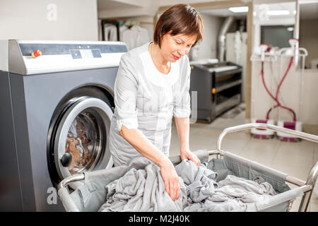 Washwoman senior dans la buanderie Banque D'Images