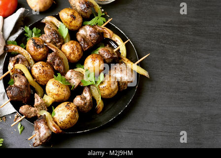 Brochettes de foie de poulet et légumes sur fond noir avec copie espace Banque D'Images