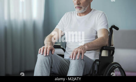 L'homme impuissant handicapées assis en fauteuil roulant et d'essayer de déplacer, de la santé, les séquences Banque D'Images