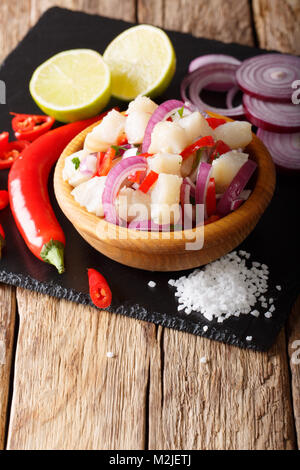 Ceviche d'Amérique du sud de pêcher la morue avec oignons et les poivrons dans un bol sur la table. vertical Banque D'Images