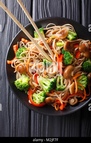 Nouilles de sarrasin aux champignons et les légumes sur une assiette. Haut Vertical Vue de dessus Banque D'Images