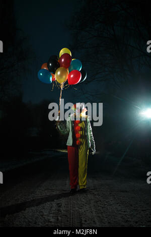 Photo de clown avec des boules dans les mains la nuit Banque D'Images